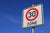 Verkehrsschild „Tempo 30 Zone“ vor klarem, blauem Himmel.