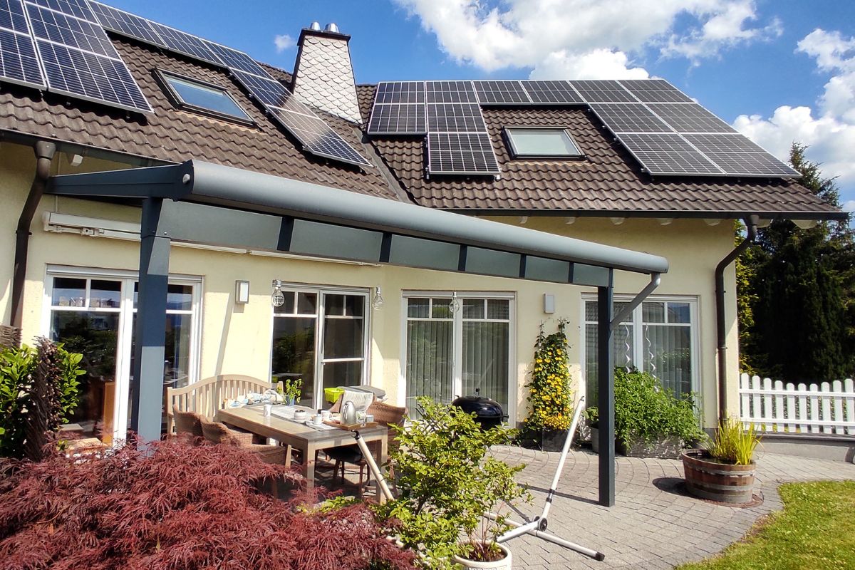 Ein Haus mit Photovoltaikanlage und einem schönen Garten