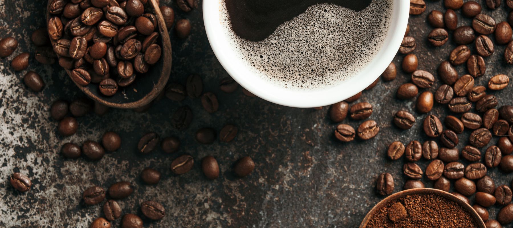 Eine Kaffetasse und Kaffeebohnen als Symbol für die Thnemenwelt Kulinarik