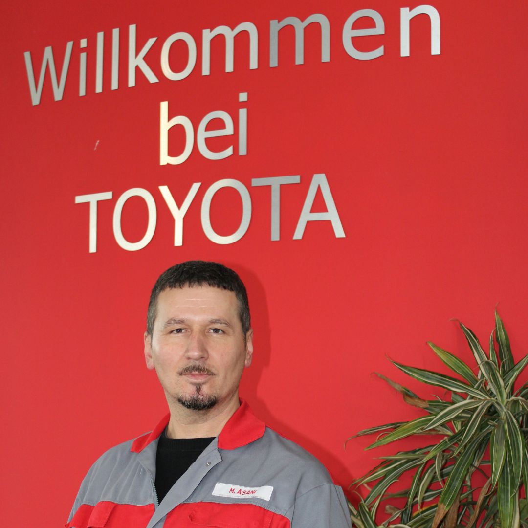 Mitarbeiter vom Autohaus Hof steht vor einem Aufsteller mit der Aufschrift "willkommen bei Toyota".