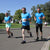 Eindrücke des Birkenfelder Firmenlaufs. Ein Team in blauen Shirts hat eine Gruppe gebildet und läuft in Richtung Ziel.