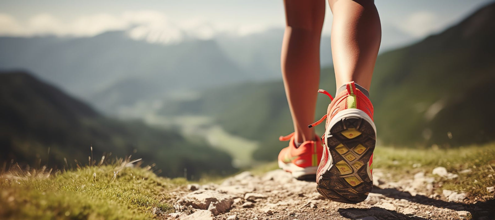 Eine Frau joggt einen steinigen pfad entlang, während die Sonne scheint.