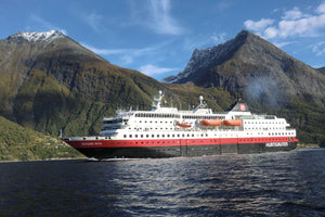 Ein Hurtigruten-Schiff namens 'Richard With' auf einem norwegischen Fjord, umgeben von steilen, bewaldeten Bergen und einem klaren blauen Himmel.