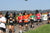 Mehrere Läufer des Birkenfelder Firmenlaufs 2023 laufen einen Asphaltweg in der Natur entlang. Alle tragen bunte T-Shirts.