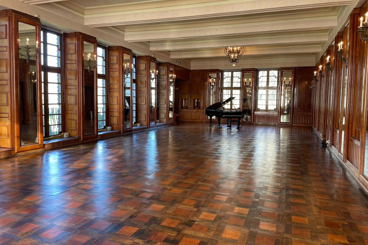 Ein großer rustikaler Raum in der Burg Namedy mit einem Piano im Hintergrund