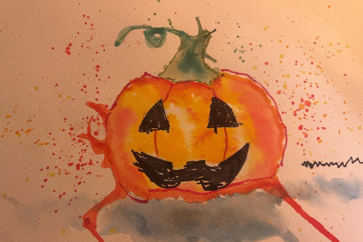 Aquarellzeichnung eines orangefarbenen Kürbisses mit schwarzen Dreiecken als Gesicht, umgeben von bunten Farbspritzern.