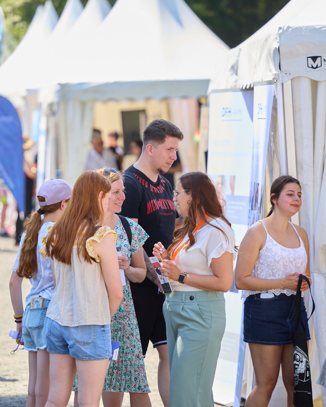 Besucherinnen und Besucher informieren sich an Ausstellerständen bei der Jobmesse „Jobs im Park“