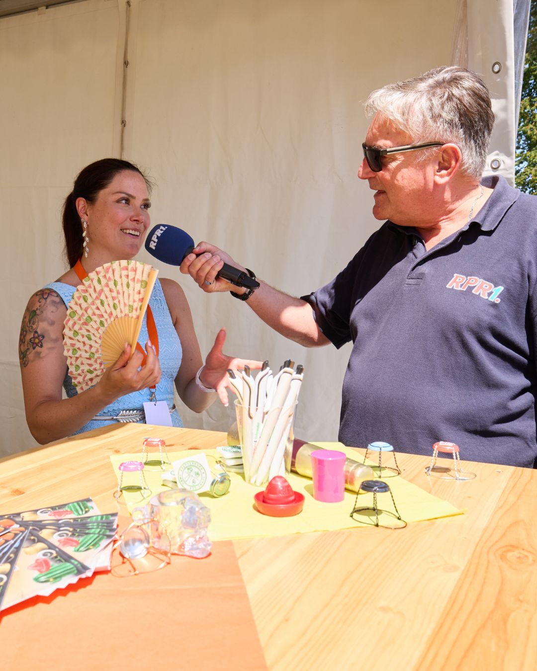 Vertreterin der Pfefferkorn & Schneider GmbH gibt bei der Jobmesse „Jobs im Park“ ein Interview für RPR1 an einem Informationsstand.