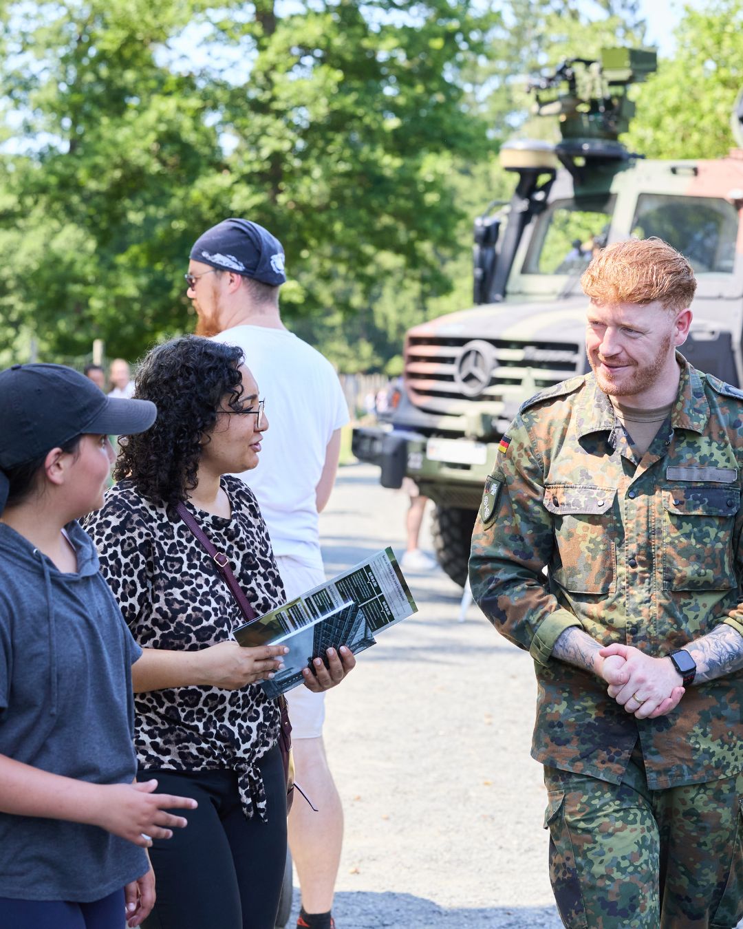 Besucherinnen und Besucher informieren sich bei der Bundeswehr über Karriere- und Ausbildungsmöglichkeiten an einem Stand der Jobmesse „Jobs im Park“.