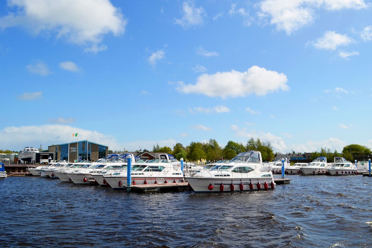 Eine Reihe von Hausbooten liegen an einem Steg bei Tageslicht.