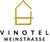 Das Logo von Vinotel in schwarzer Schrift. Oben ist ein in Gold mit Strichen gemaltes Haus, auf einem weißen Hintergrund