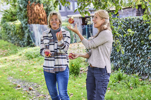 Zwei Frauen beim Pflücken von Äpfeln