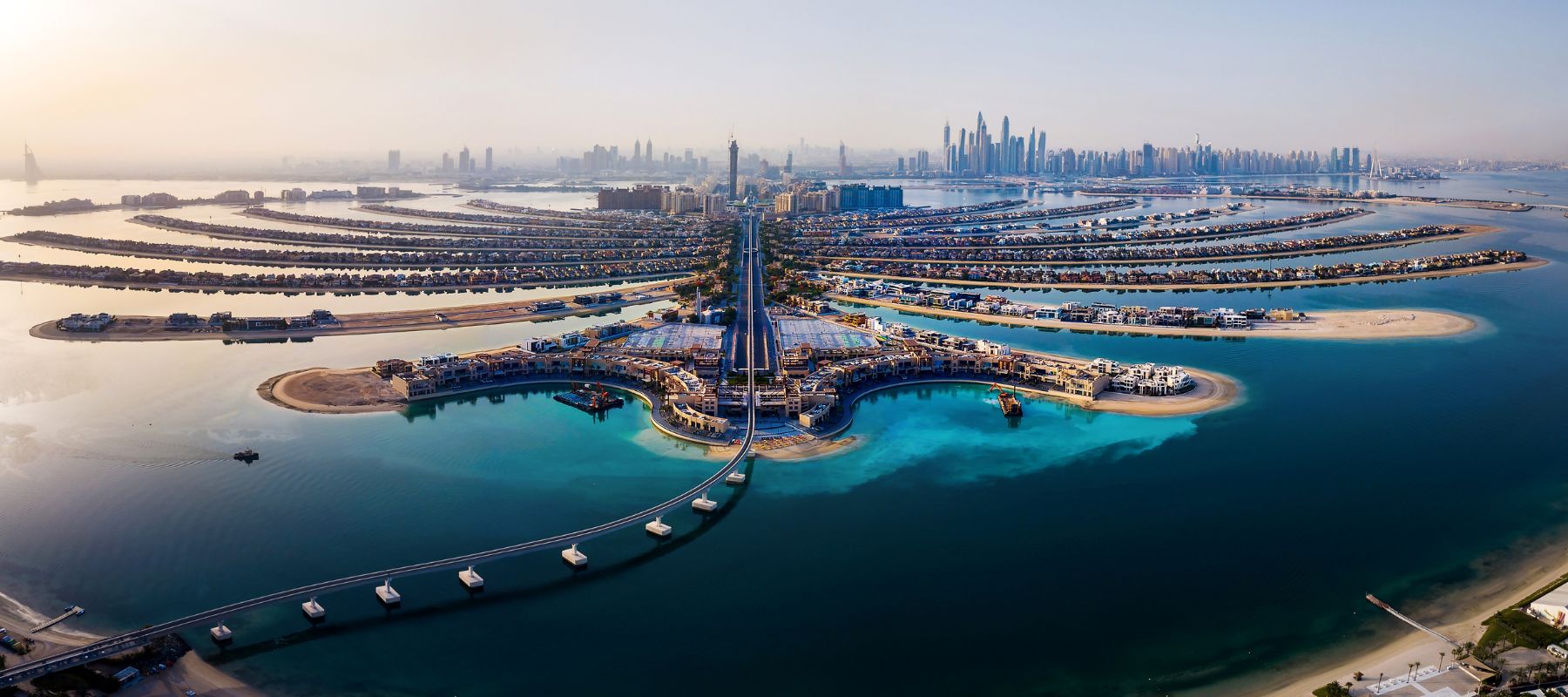 Ein Panoramablick auf die beleuchtete Dubai Marina und ihre Wolkenkratzer, die sich entlang des Wassers erstrecken.