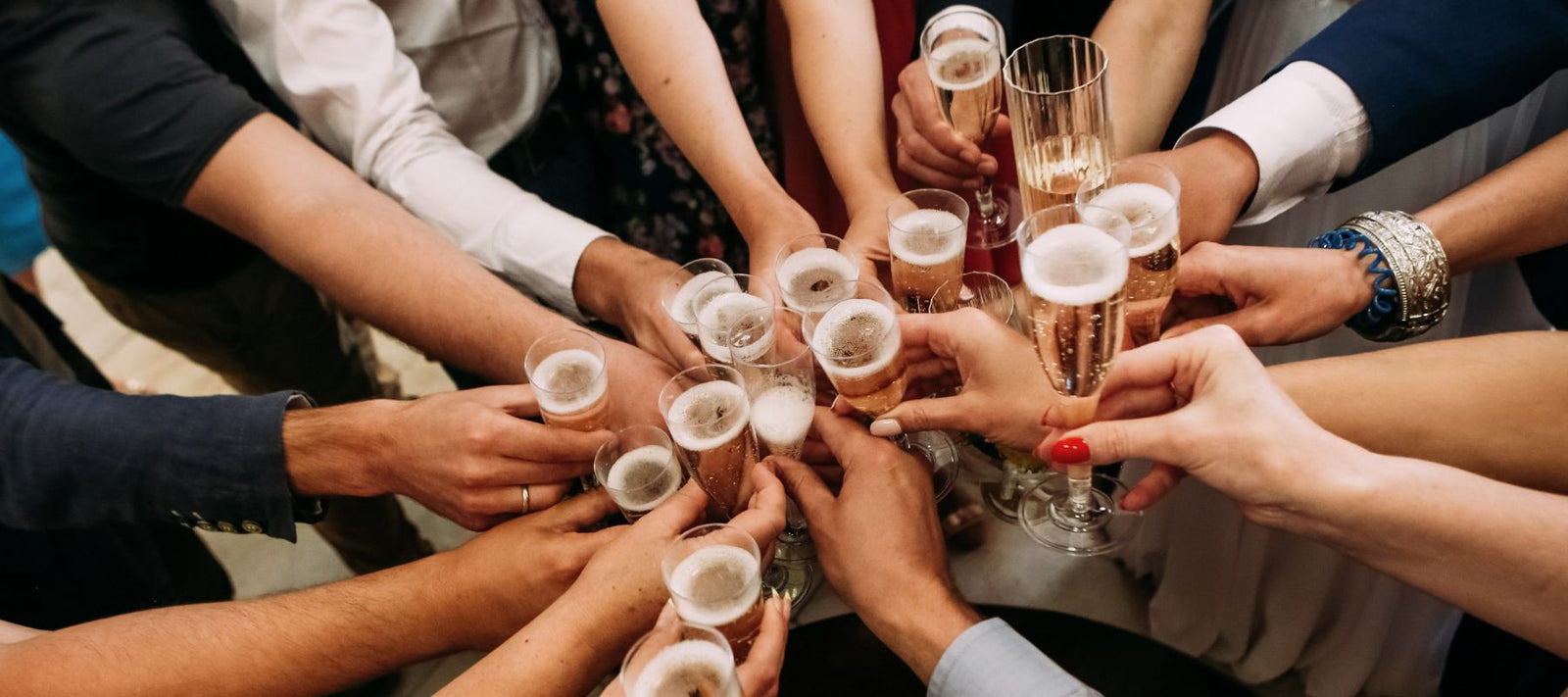 Eine Gruppe an Personen stößt auf ein erfolgreiches Event mit Sekt an.