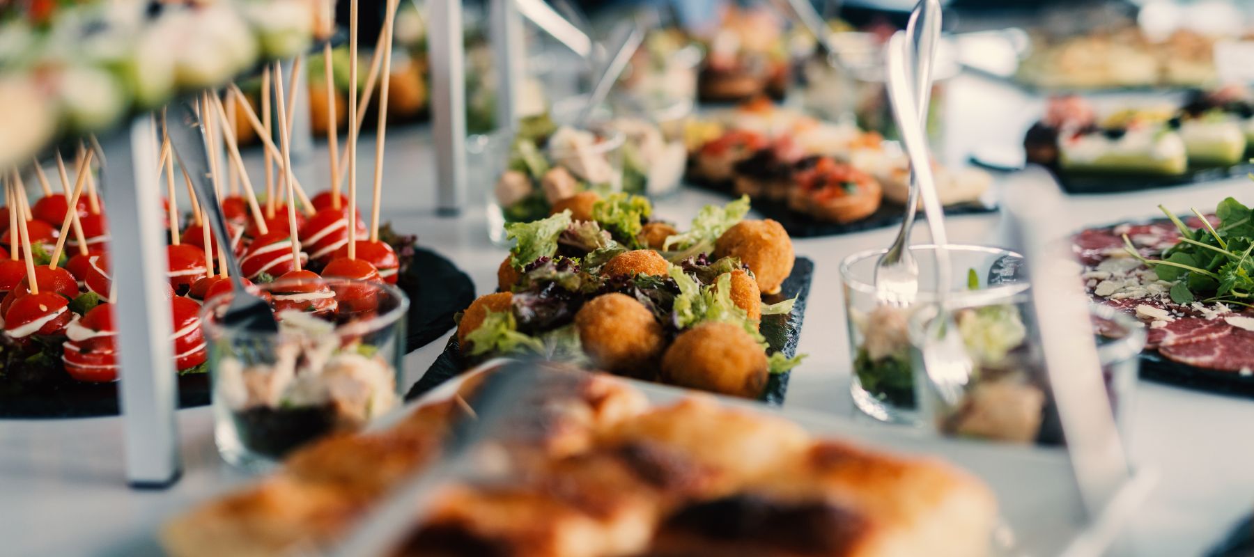 Leckeres Essen vom Caterer steht auf einem weißen Tisch.