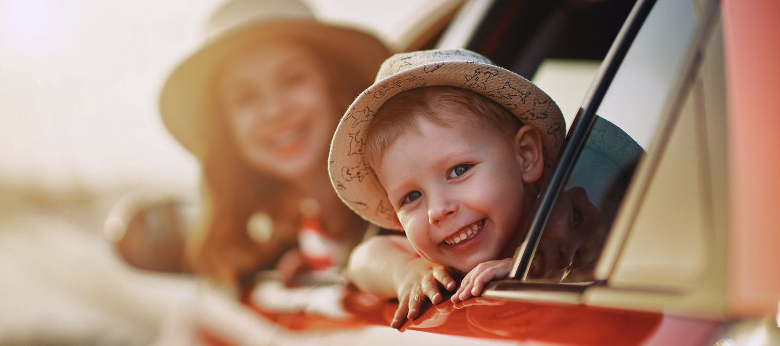 eine Mutter und ihr Kind schauen aus einem Autofenster heraus.