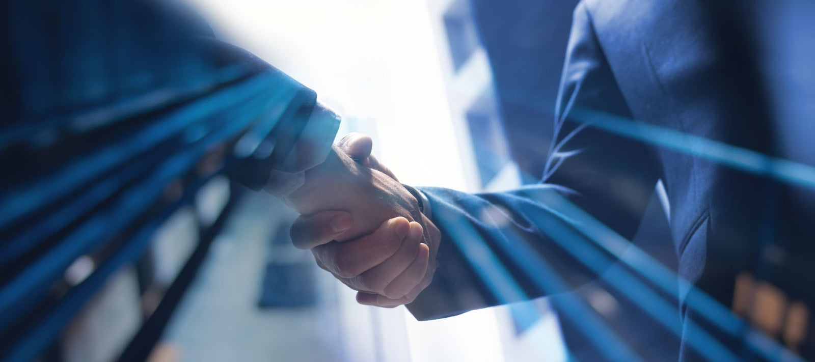 Zwei Personen schütteln sich in einer Lobby die Hand